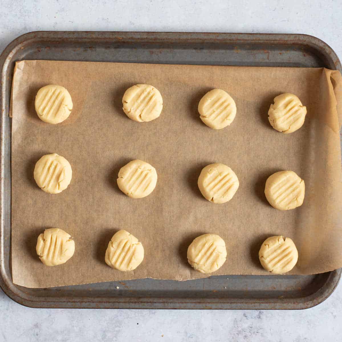 Fork biscuits on baking tray.