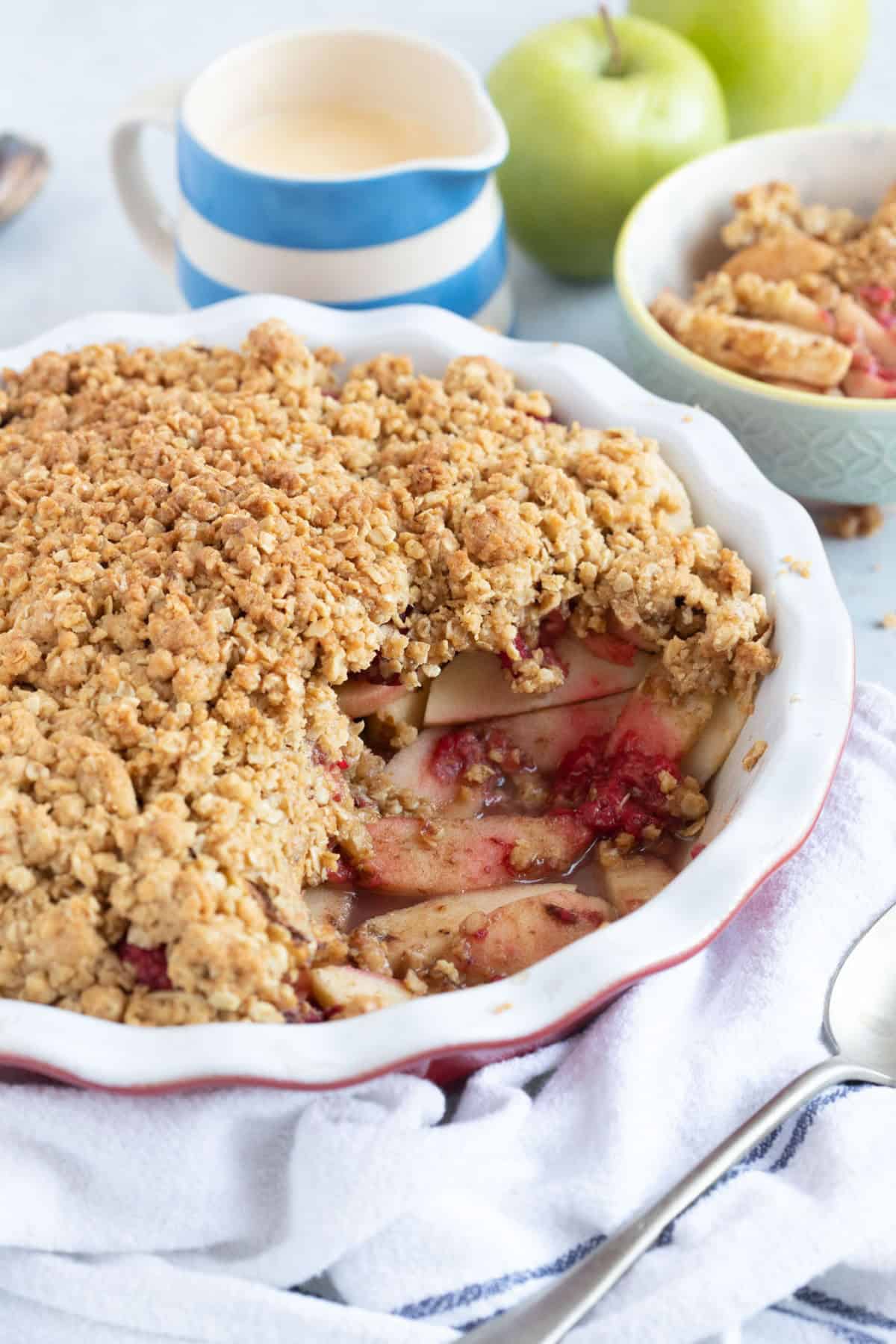 Apple and raspberry crumble in pie dish.