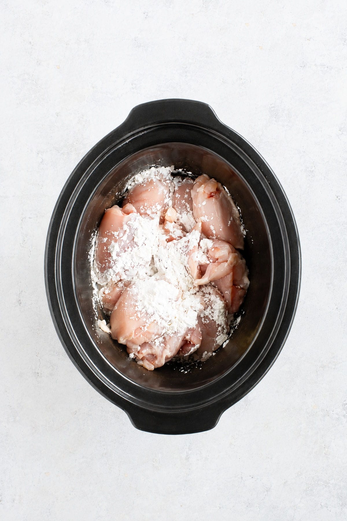 Chicken thighs in slow cooker with corn flour.