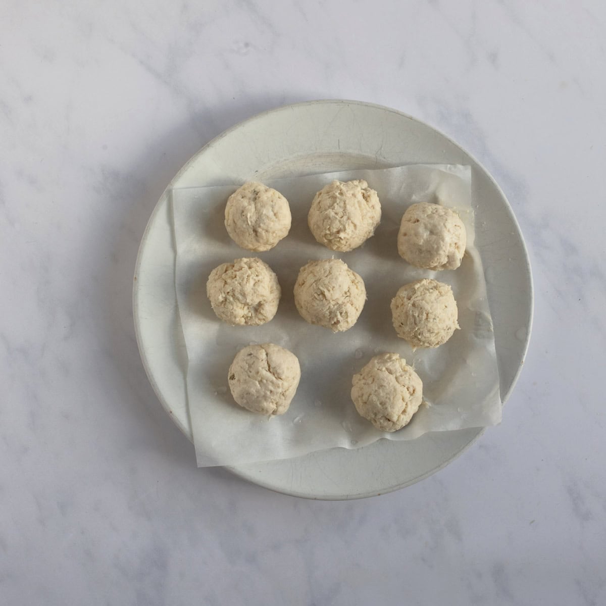 8 suet dumplings on a plate.