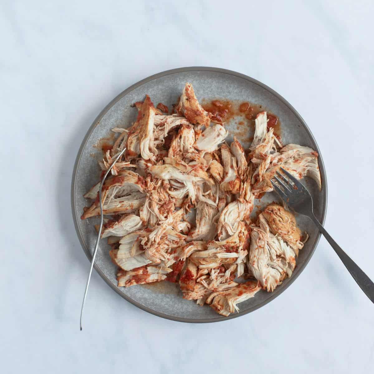 Chicken breasts shredded on a plate.
